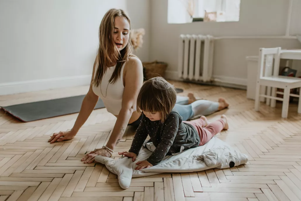 vrouw en kind op houten vloer yoga oefening