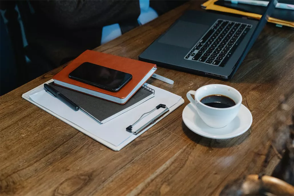 tafel met agenda en blokjes koffie en laptop