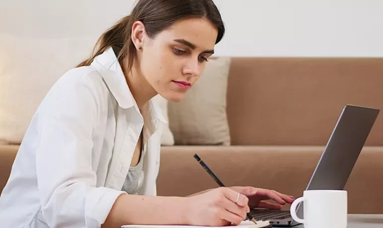 vrouw werkend met laptop, koffie schrijvend aan koffietafel