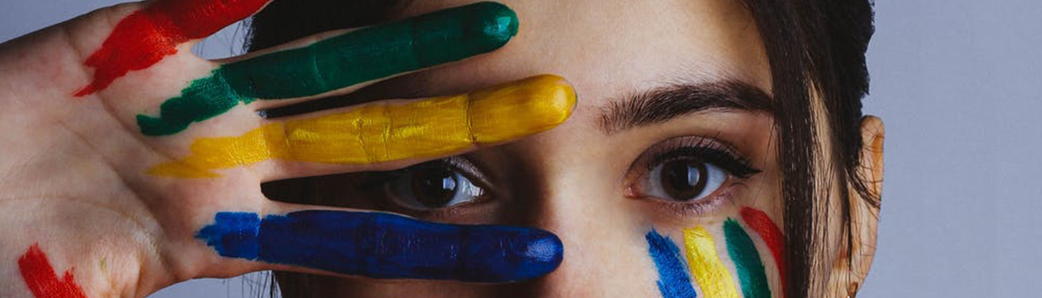 vrouwen ogen met vingers in groen geel blauwvoor gezicht