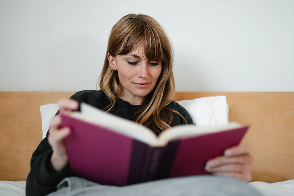 Vrouw die een boek in bed leest